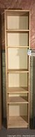 Front view of the skinny, tall bookshelf showing 7 shelves and a light wood finish.