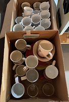 Box showing over 20 white Steelite mugs stacked inside.