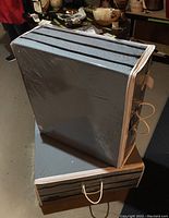 Two folded mattress carrying cases stacked on concrete floor