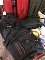 Photo showing entire lot of bags including Everest College backpack, nylon garment bag, rolling duffel, and additional tote bag.