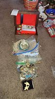 Overview photo showing wooden jewelry box, plastic bags with various costume jewelry pieces, and a small black jewelry box.