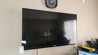 Samsung TV mounted on wall with reflection on screen