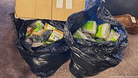Two large black bags filled with multiple packs of Odor-Eaters Sneaker Tamers tube socks in original packaging.