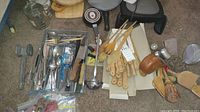 Overview photo showing multiple kitchen utensils including wooden spoons, spatulas, ladle, metal meat tenderizer and flatware container with knives, forks, and spoons.