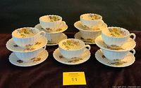 Full set of 9 teacups with saucers plus 1 extra teacup arranged on display