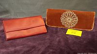 Red leather HOBO wallet and dark orange velvet beaded evening bag shown side by side.
