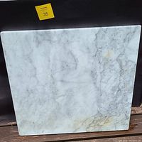 Top side view of the rectangular marble table top showing natural veining and some discoloration.