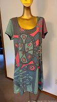 Front view of colorful abstract short sleeve knit dress on mannequin.