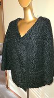 Front view of vintage black curly lamb's wool jacket on mannequin, showing texture and shape.