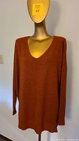 Deep orange v-neck sweater on mannequin showing front view