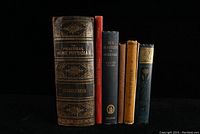 Seven antique and vintage medical-related books aligned upright showing spines and some detail on covers.