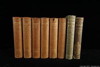 Eight antique history books from the 1800s shown upright against a black background. Six volumes of Gibbon's Rome with brown leather spines, embossed decorations, and gilt titles, alongside two books with green-grey cloth covers including one on Napoleon.