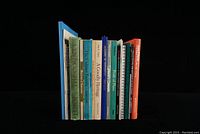 View of 20 local history books related to Prince Edward County, arranged standing upright showing spines with various titles and colors.