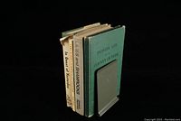 Four books standing upright in a book holder, titles visible: Pioneer Life County of York, In Quest of Yesterday, Lilies and Shamrocks, Lake Huron's Summer Dance Pavilions.