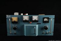 Front view of the vintage vacuum tube radio transmitter showing analog meters, knobs, and metal handles.