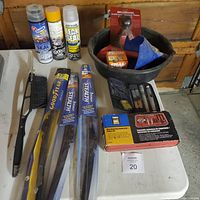 Lot items displayed on a table including used oil pan, funnels, aerosol cans, windshield wiper blades, small automotive parts, gasket scraper and bearing separator kit in original box.