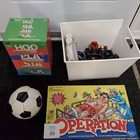 Photo showing Hoopla Stacks game box, Operation board game box with classic cartoon cover, and ceramic soccer ball coin bank.