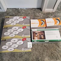 Photo showing three boxes each containing 6 GU10 recessed lighting bulb kits and other lighting kit boxes.