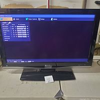 Sharp Aquos 37 inch LCD TV powered on showing picture settings menu on screen on grey surface