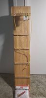 Wooden toboggan laid flat showing 5 slats and pull rope at front