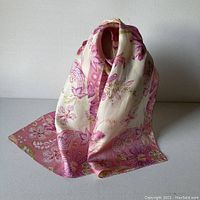 Silk scarf displayed standing and draped to show texture and print colors.