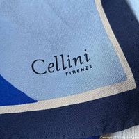 Close-up of Cellini Firenze logo printed on silk scarf showing fabric texture and brand.