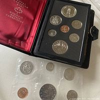 1977 Canadian coin set with seven coins in black foam holder inside black case with red satin interior, coins sealed, case partly unglued and repaired with glue.