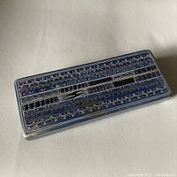 Top view of rectangular soapstone box showing intricate carved and painted geometric patterns in black and white.