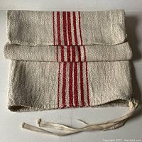 Folded view of the vintage French grain sack showing the hemp texture and red stripes along the center.