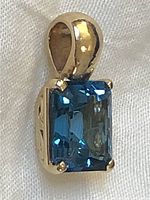 Front view showing emerald cut London blue topaz and four-prong 14K gold setting