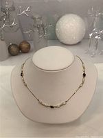 Full view of the necklace displayed on a bust with holiday décor in background