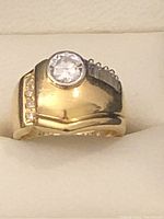 Front view of ring showing bezel-set round brilliant cut diamond and gold shank