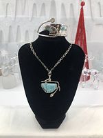Front view of necklace pendant and cuff bracelet displayed on a black bust