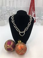 Full view of necklace on black display bust with holiday decor in background