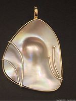 Front view of pendant showing lavender blister pearl with yellow gold wire accents and two white gold stems each topped with a small diamond