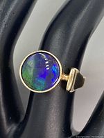 Front view showing round ammolite doublet in yellow gold bezel