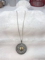 Full view of pendant and chain laid flat on white towel background