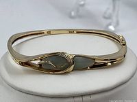 Overall profile of the hinged bangle on white stand