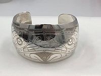 Front view of cuff showing engraved totem face motif