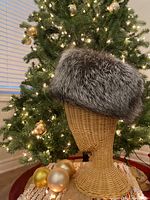 Hat on wicker head form, front view showing overall shape and fur texture