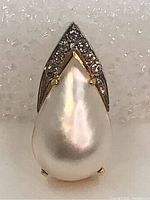 Front view on white foam background, showing teardrop pearl and diamond cap
