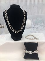 All three items displayed on black bust and pillows