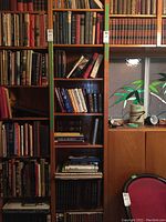 Wide view of wooden bookshelves filled with assorted hardcovers and paperbacks
