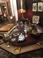 Overall display of assorted decorative items and wooden bowl on an octagonal table.