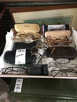 Overview photo of eyeglasses and cases spread inside a box, showing different eyeglasses with cases and bubble wrap.