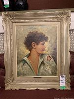 Full view of framed oil painting depicting young person in profile smoking a cigarette, signed R. Lanzi.