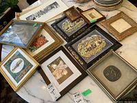 Overview of several framed prints and loose frames laid out on a table surface