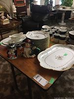 Group shot showing platter, dinner plates, figurines and background mugs