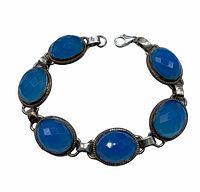 Close-up angle of the 7 inch ladies bracelet showing blue oval faceted stones set in 925 sterling silver with lobster claw clasp.