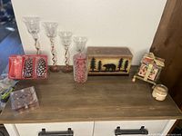 Wide view of all candles and candle holders on wooden surface showing arrangement and designs